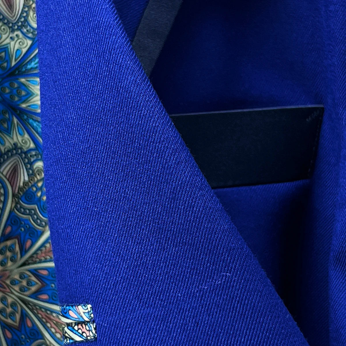 Boutonniere buttonhole on the peak lapel of the cobalt blue Westwood Hart tuxedo, perfectly positioned for formal floral accessories