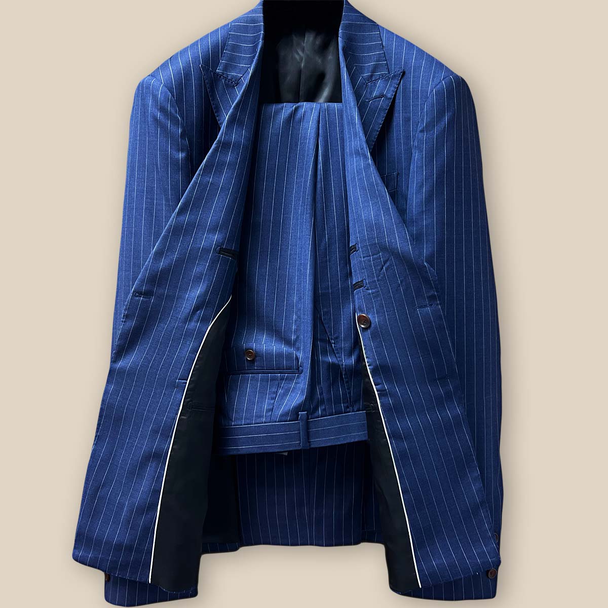 Front view of double-breasted dark blue pinstripe suit, showcasing peak lapels and slanting flap pockets