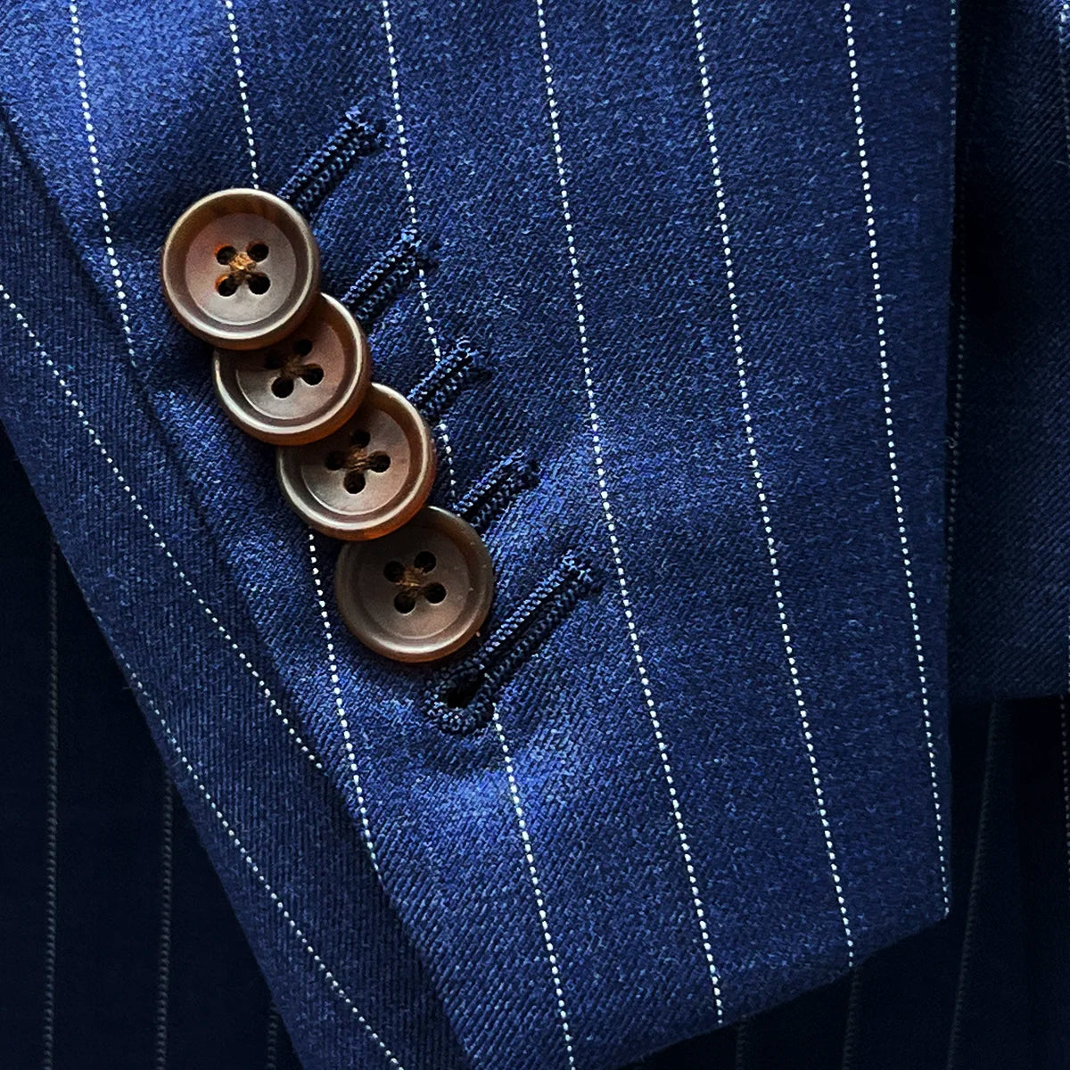 Detail of suit sleeve cuff, showing functional buttonholes with brown horn buttons