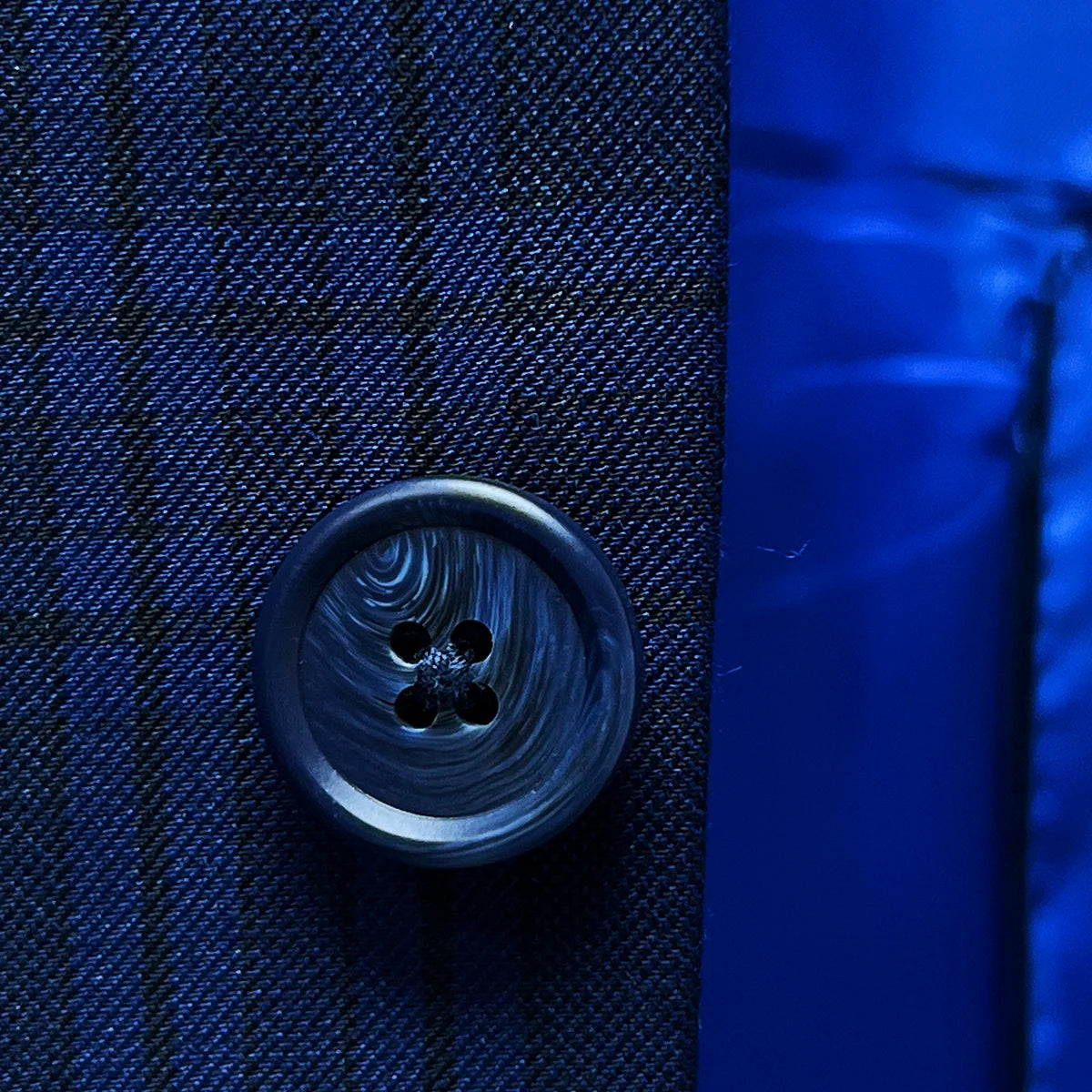 Detailed view of navy horn buttons on dark blue Westwood Hart suit jacket