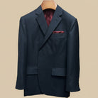 Close-up view of dark charcoal grey birdseye suit jacket showing contrast deep burgundy accent buttonhole with hand-finished stitching detail