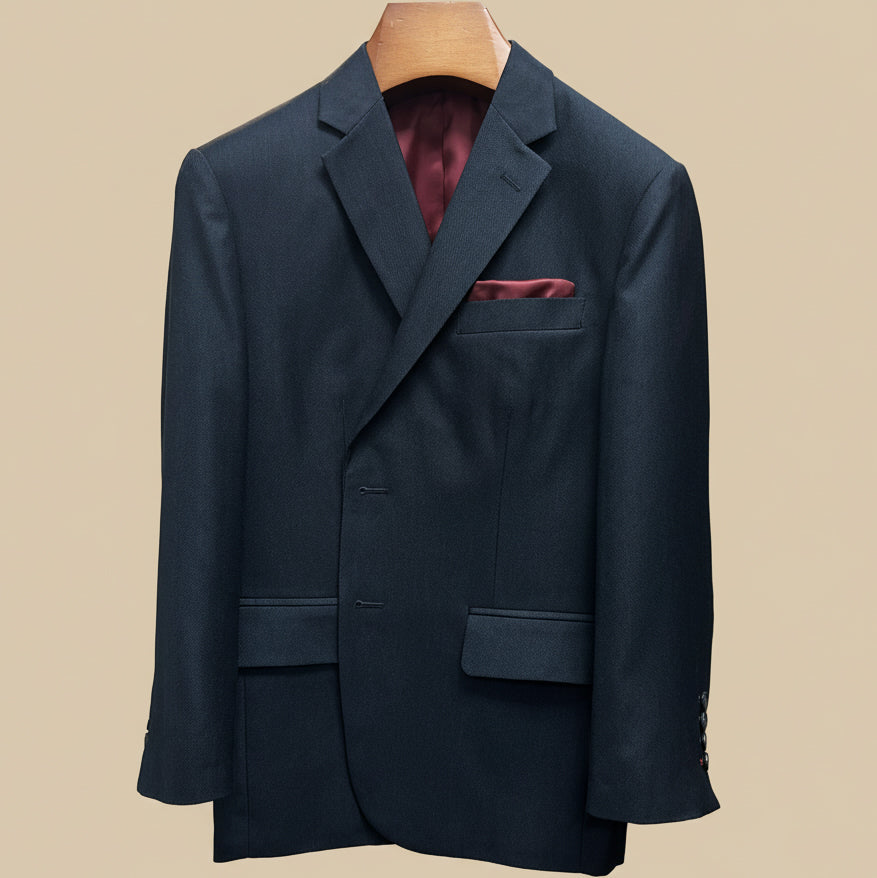 Close-up view of dark charcoal grey birdseye suit jacket showing contrast deep burgundy accent buttonhole with hand-finished stitching detail