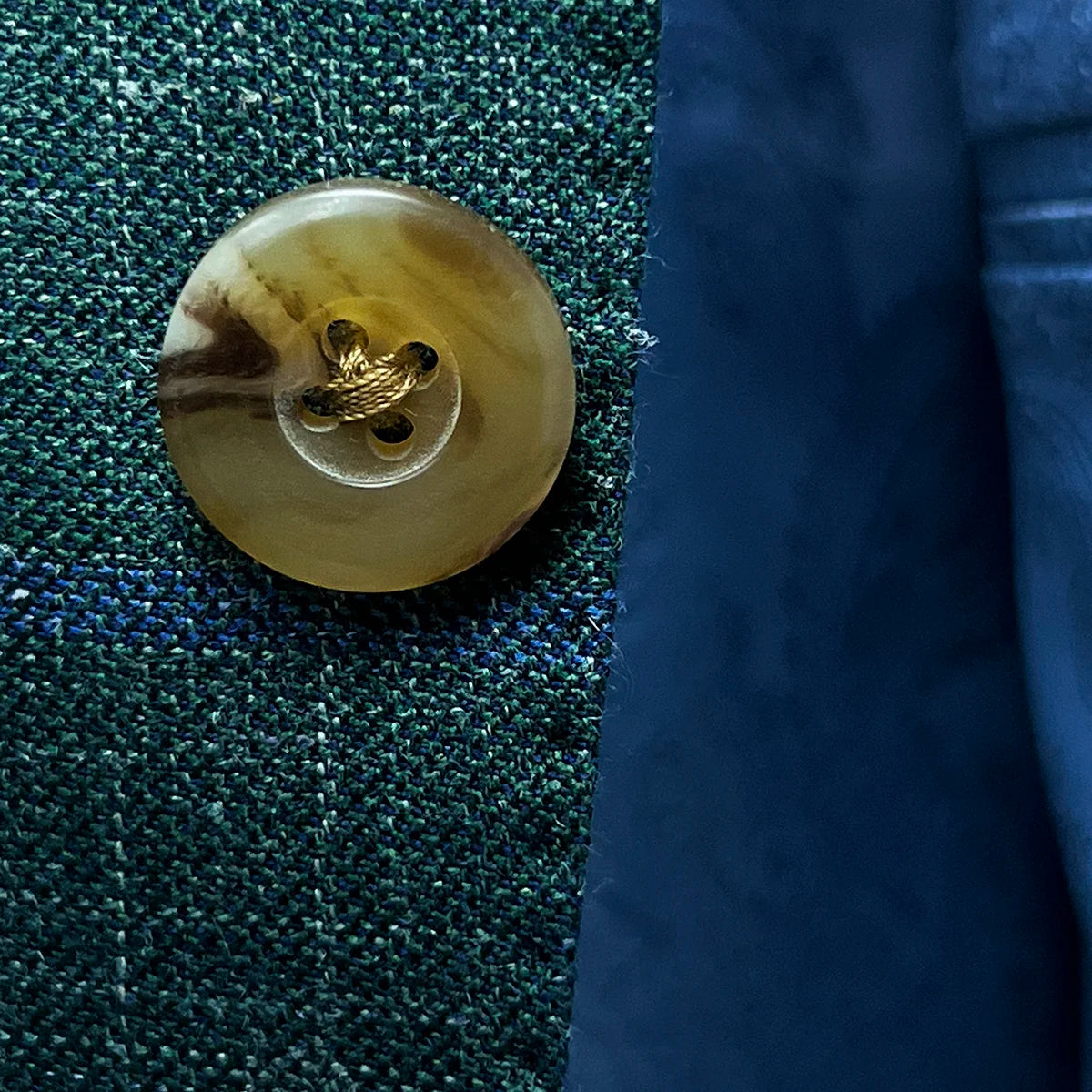 Close-up of tan horn marble buttons on dark green Westwood Hart windowpane sport coat, highlighting their unique texture and color