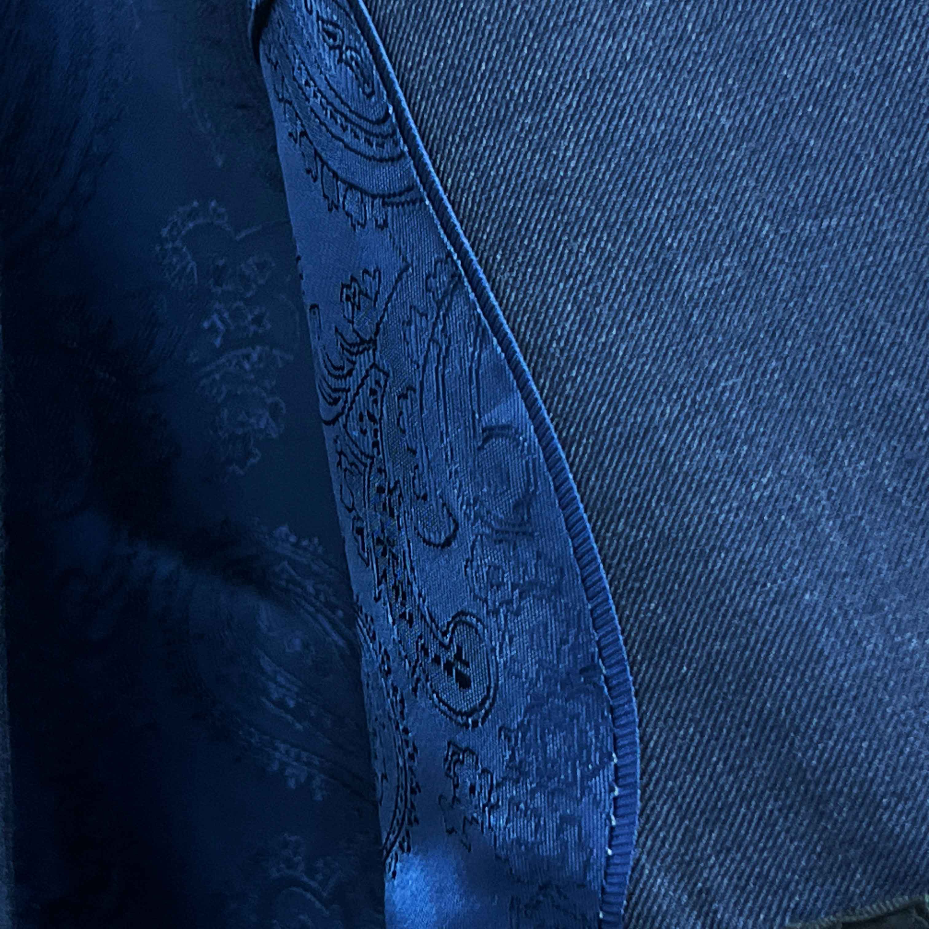 Close-up of a blue denim fabric with intricate stitching detail