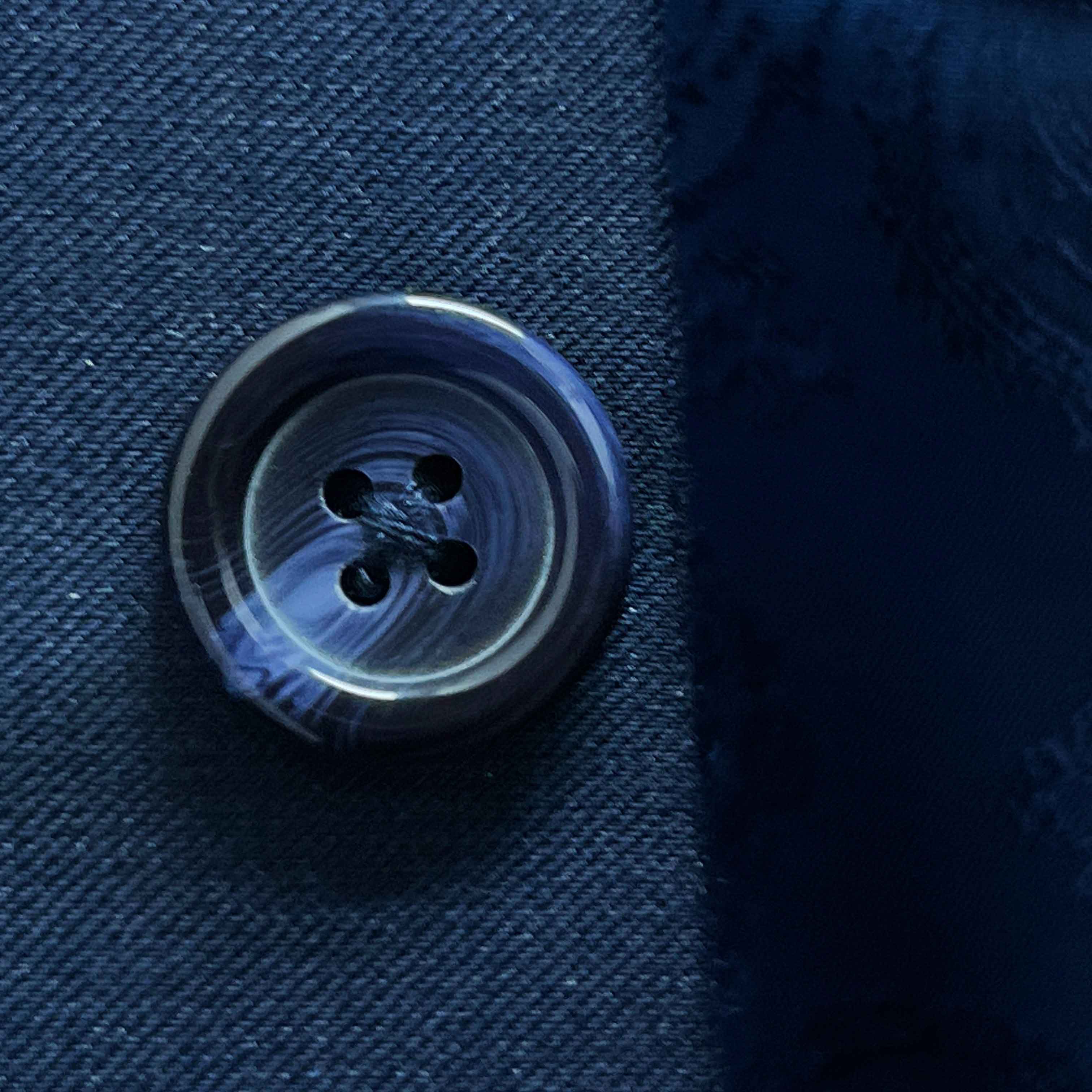 Close-up of a button on blue fabric