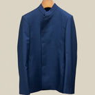 Close-up view of deep blue solid Nehru suit jacket showing marbled dark blue horn buttons with hand-finished stitching detail