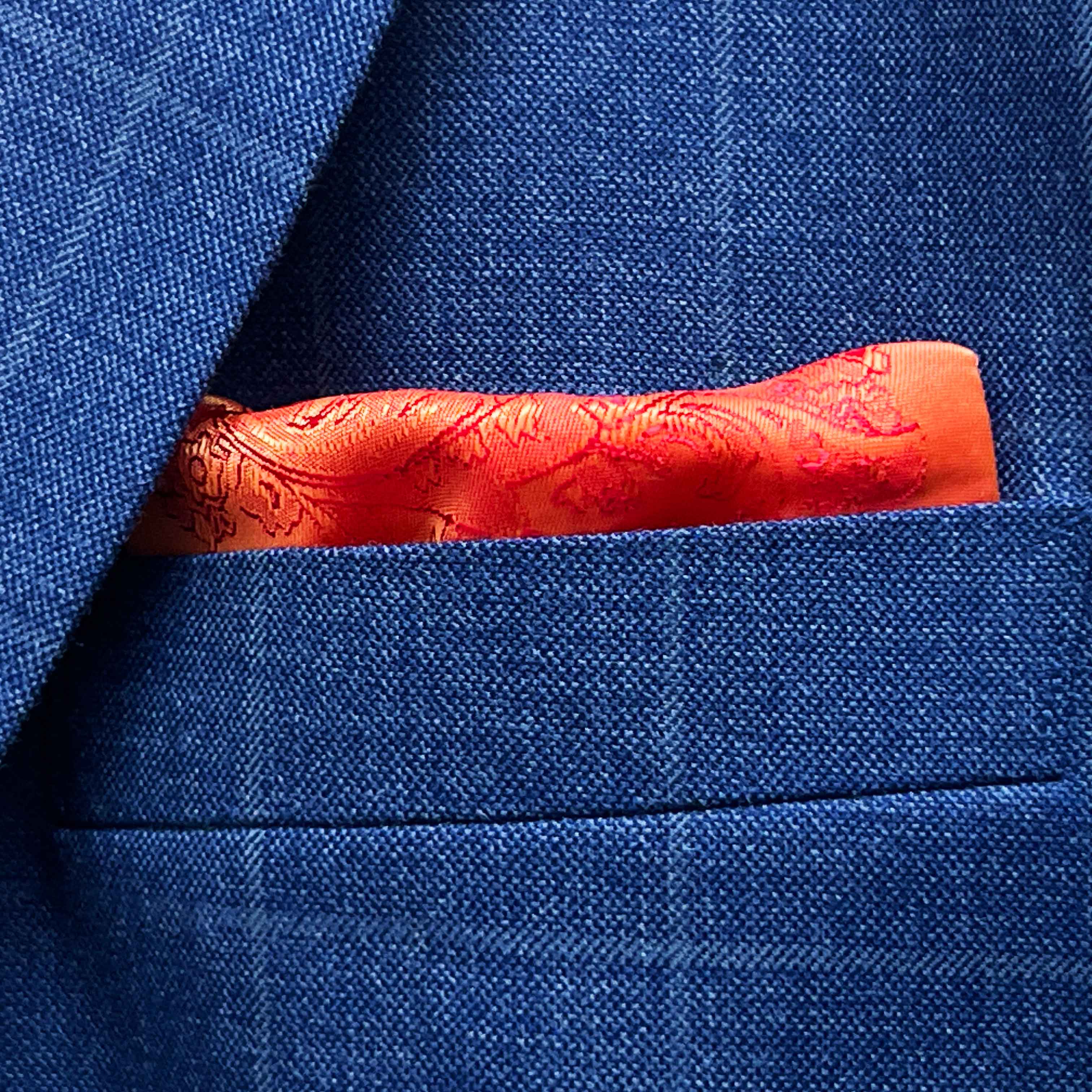 Breast pocket of deep blue windowpane check suit jacket with built-in pocket square holder and hand-finished edges