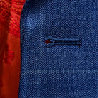 Detailed macro shot of hand-finished buttonhole stitching on deep blue windowpane check suit with orange contrast thread