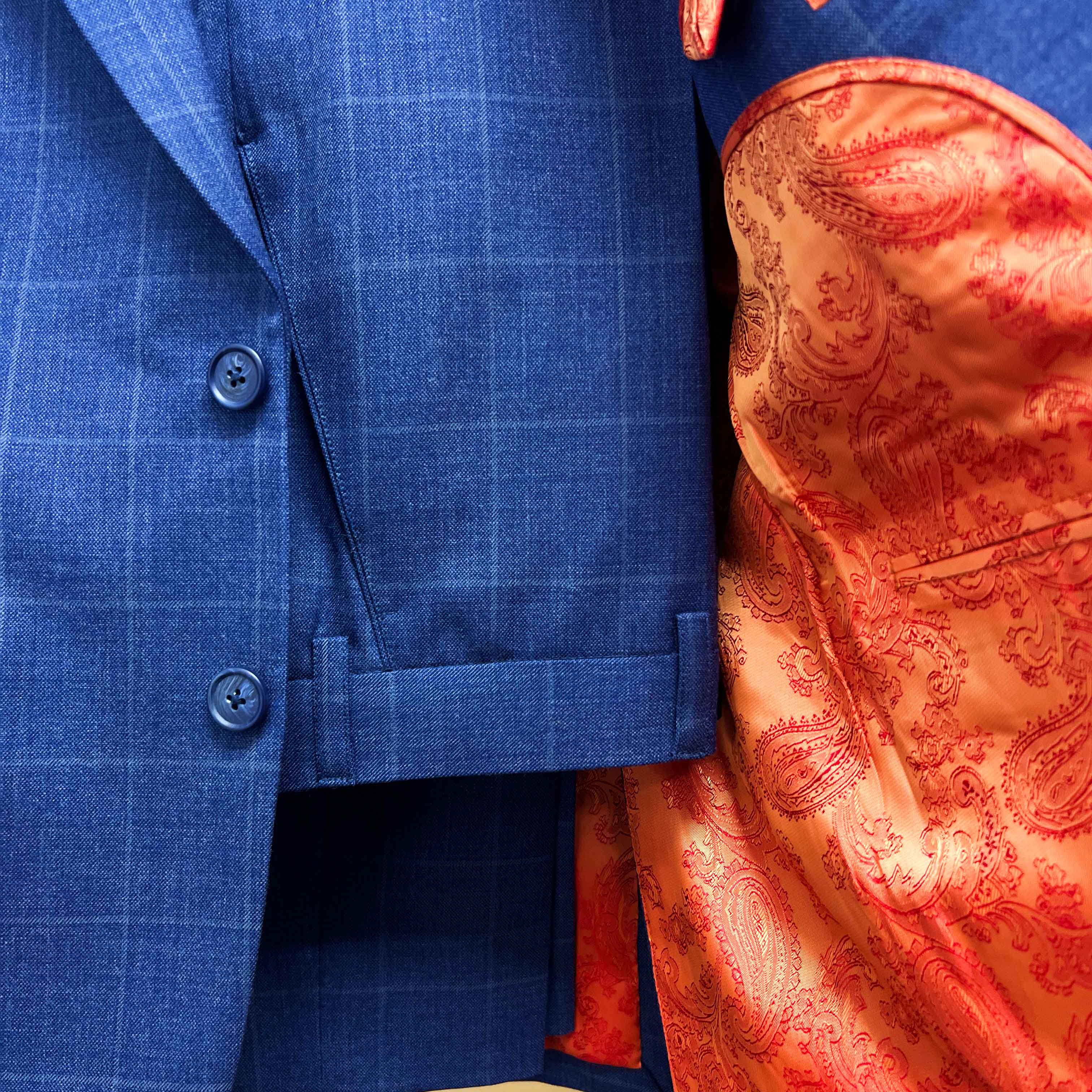 Complete two-piece deep blue windowpane check custom suit displayed on hanger showing jacket and trousers with windowpane pattern