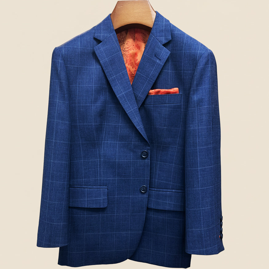 Front button panel of deep blue windowpane check suit jacket featuring marbled dark blue horn buttons and hand pick stitching
