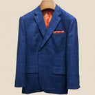 Close-up view of deep blue windowpane check suit jacket showing contrast orange accent buttonhole with hand-finished stitching detail