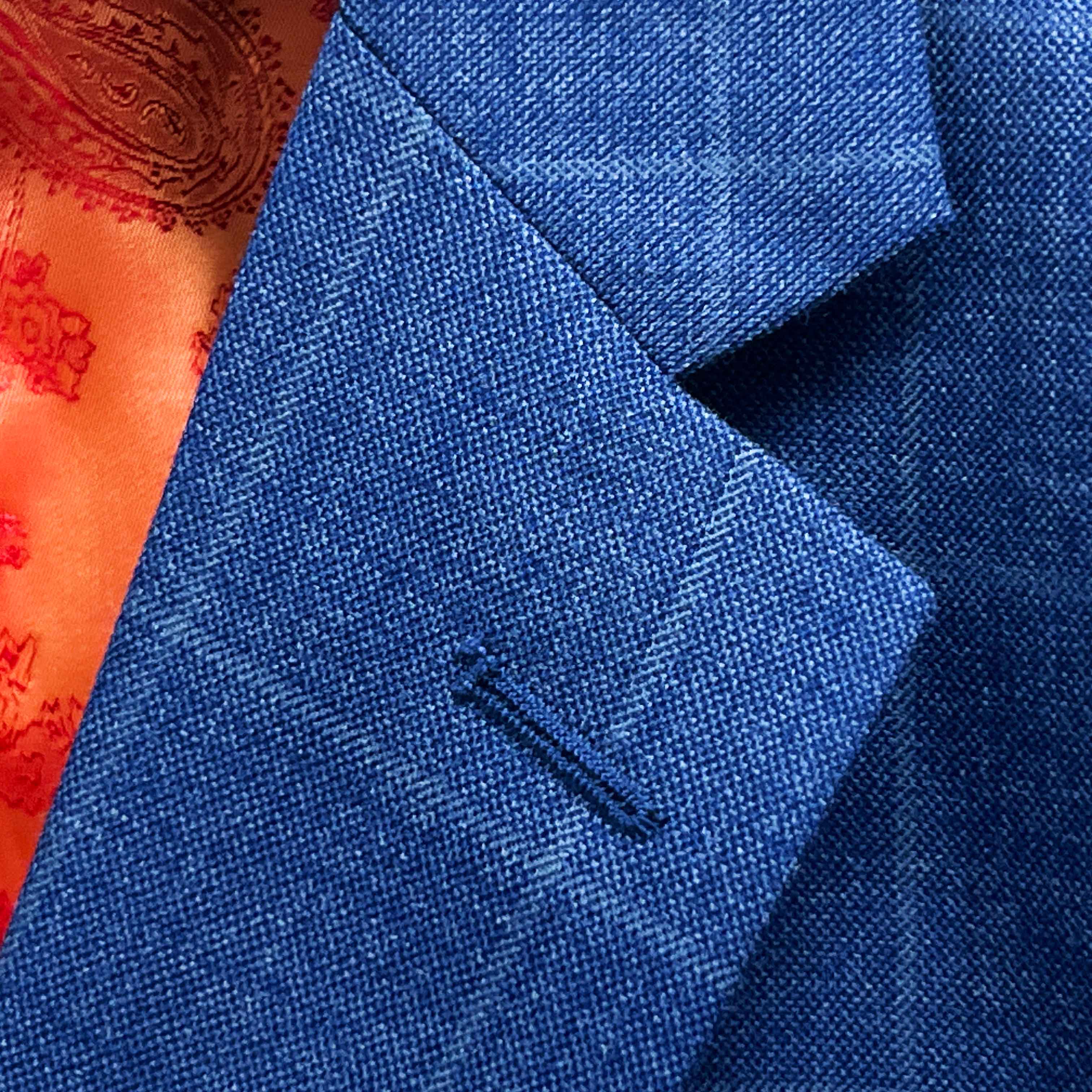 Classic notch lapel detail on deep blue windowpane check suit jacket showing hand pick stitching and windowpane pattern