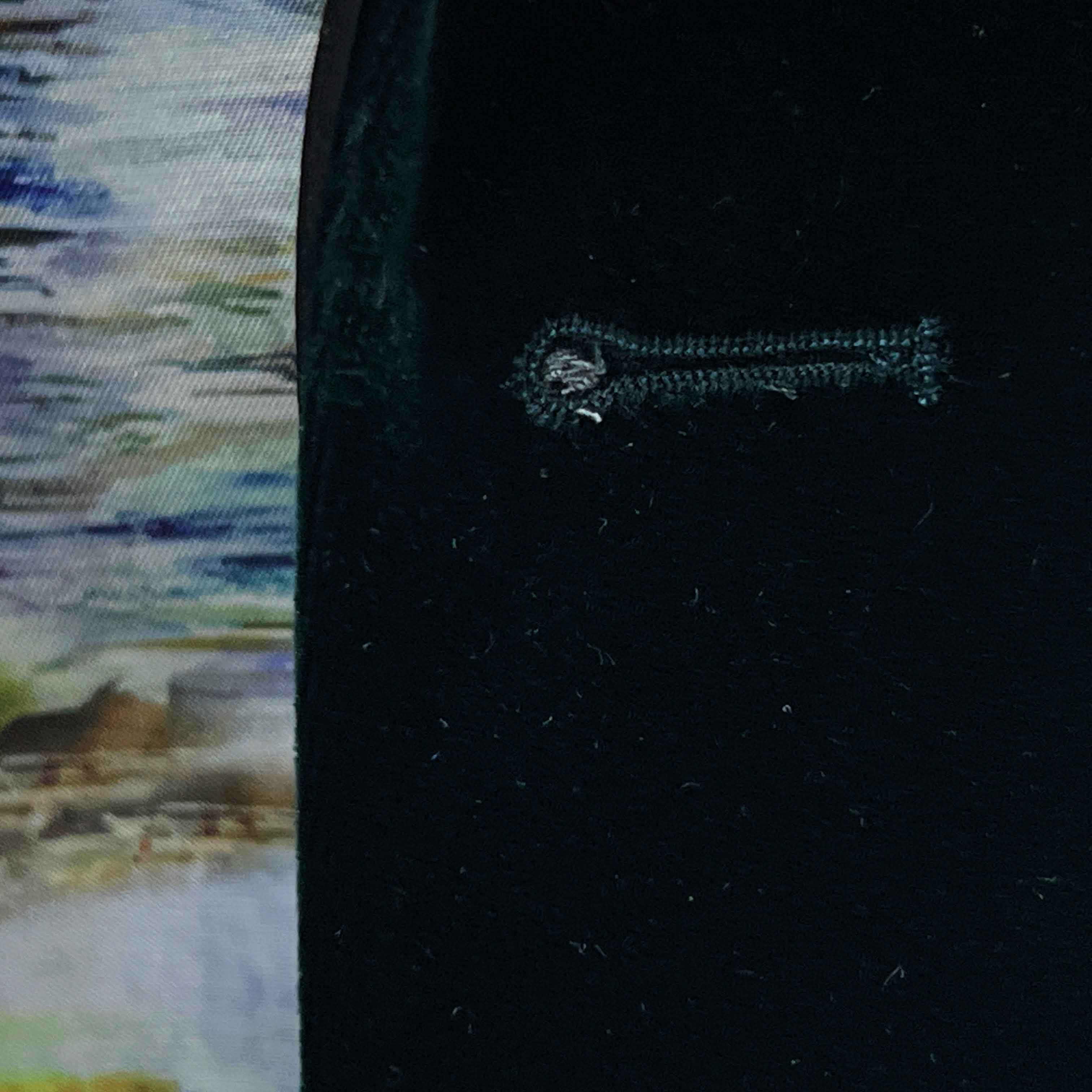 Close-up of a black fabric with an embroidered key design on a blurred background.