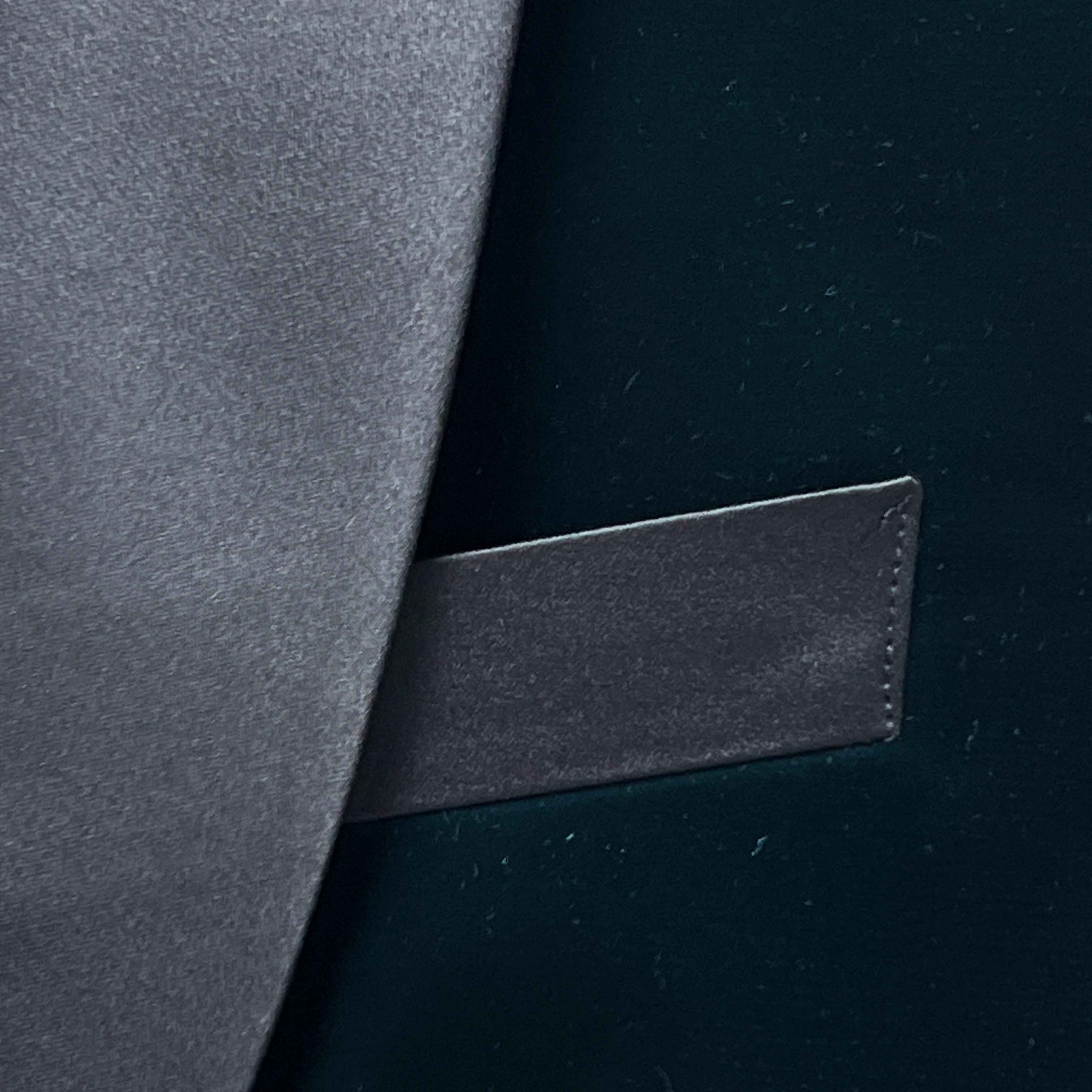 Close-up of a dark gray leather patch on a black background