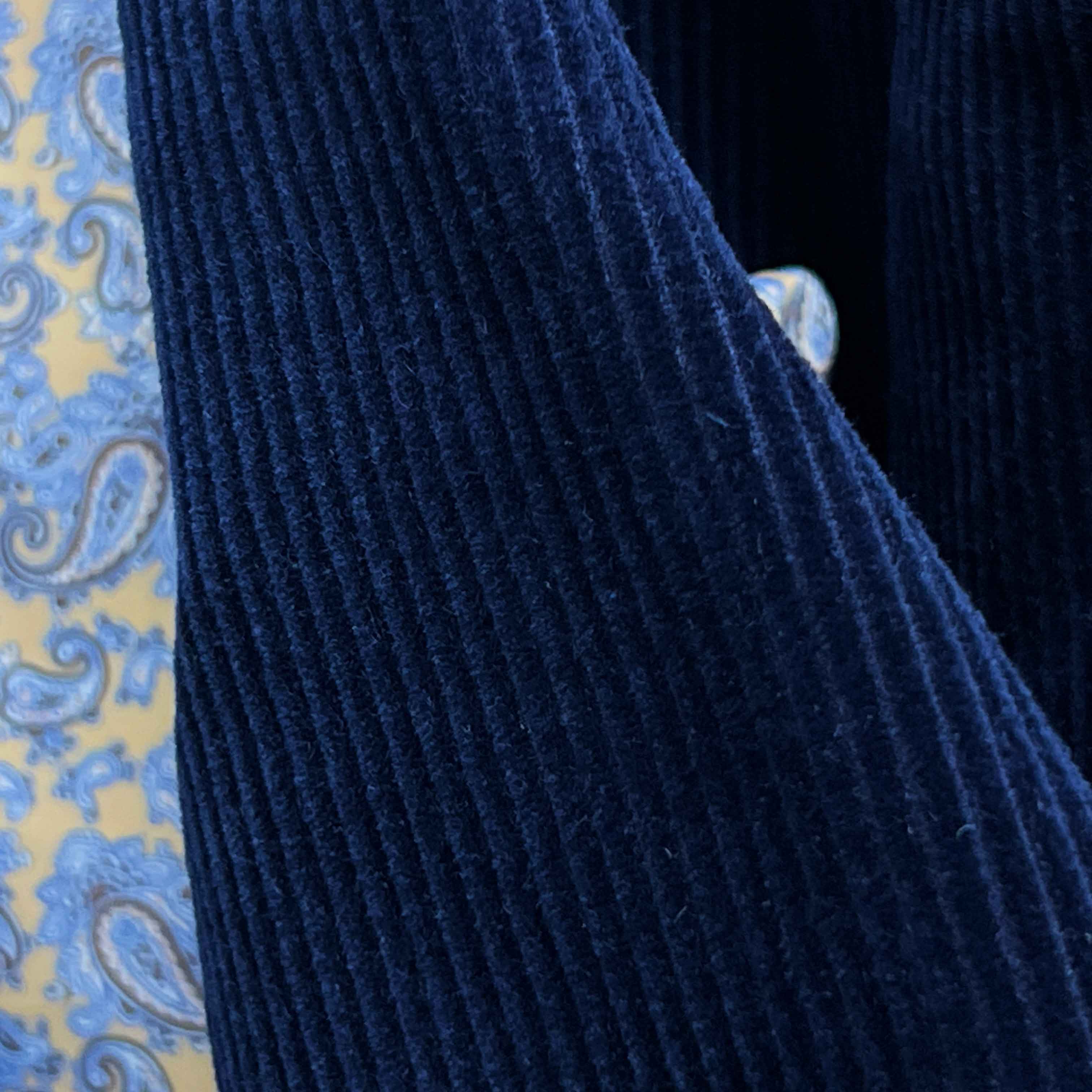 Macro detail of 10-wale corduroy texture in deep navy blue showing the distinctive vertical ribbed pattern
