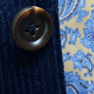 Close-up of tortoiseshell brown horn buttons on deep navy blue corduroy sport coat showing natural patterns