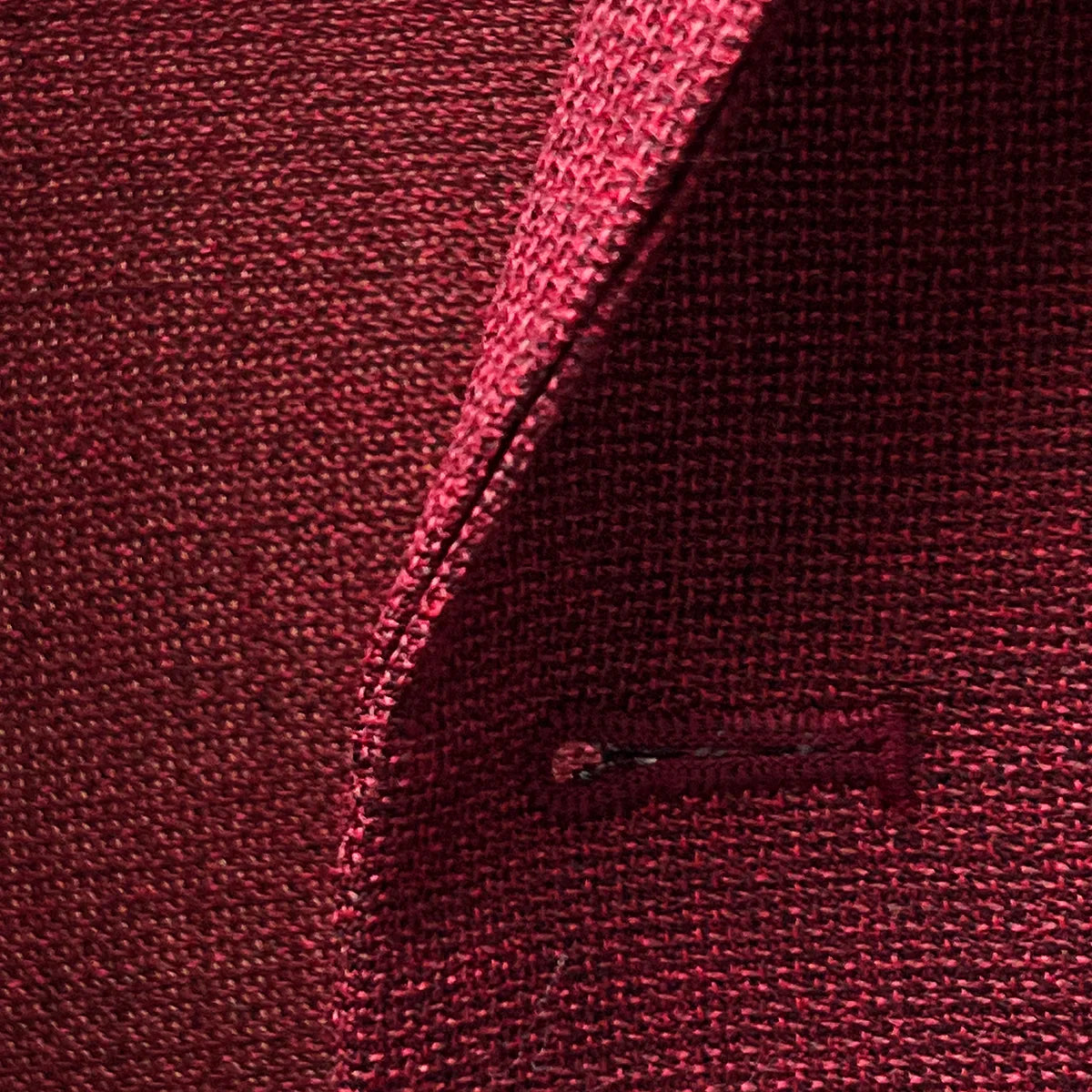 Macro detail of deep red basketweave fabric texture showing the intricate weave pattern and wool fiber quality