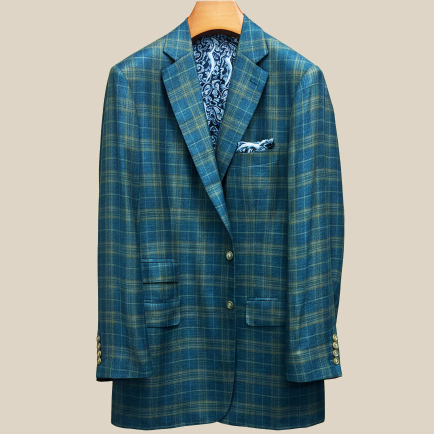 Front button panel of deep teal green multi check suit jacket featuring olive green horn buttons and hand pick stitching