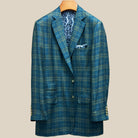 Front button panel of deep teal green multi check suit jacket featuring olive green horn buttons and hand pick stitching