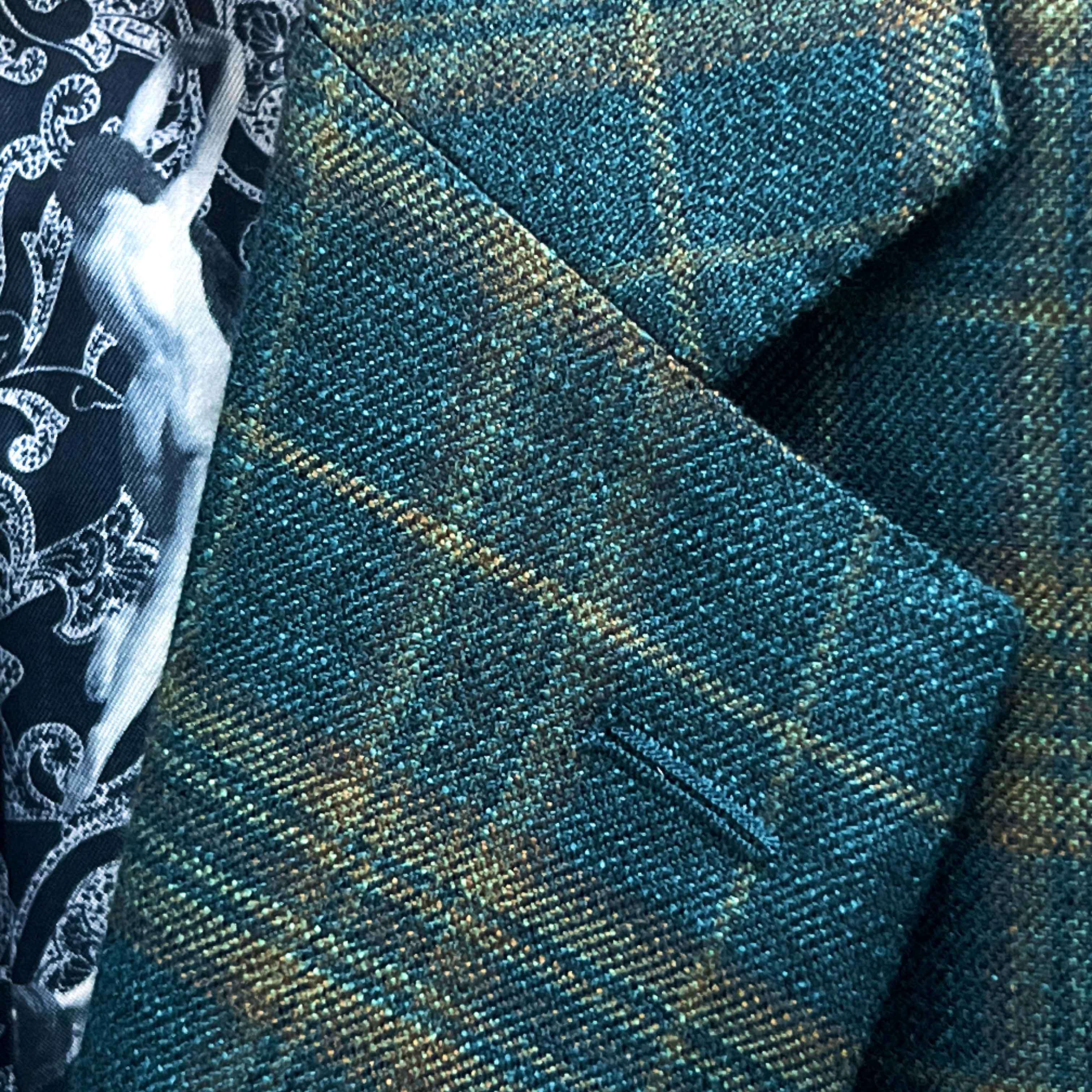 Classic notch lapel detail on deep teal green multi check suit jacket showing hand pick stitching and plaid check pattern