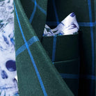 Close-up of Super 130s Australian merino wool fabric showing forest green base with bright blue windowpane check pattern