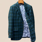 Interior left side of forest green windowpane sport coat displaying white and light blue floral and skull pattern lining with inner pocket