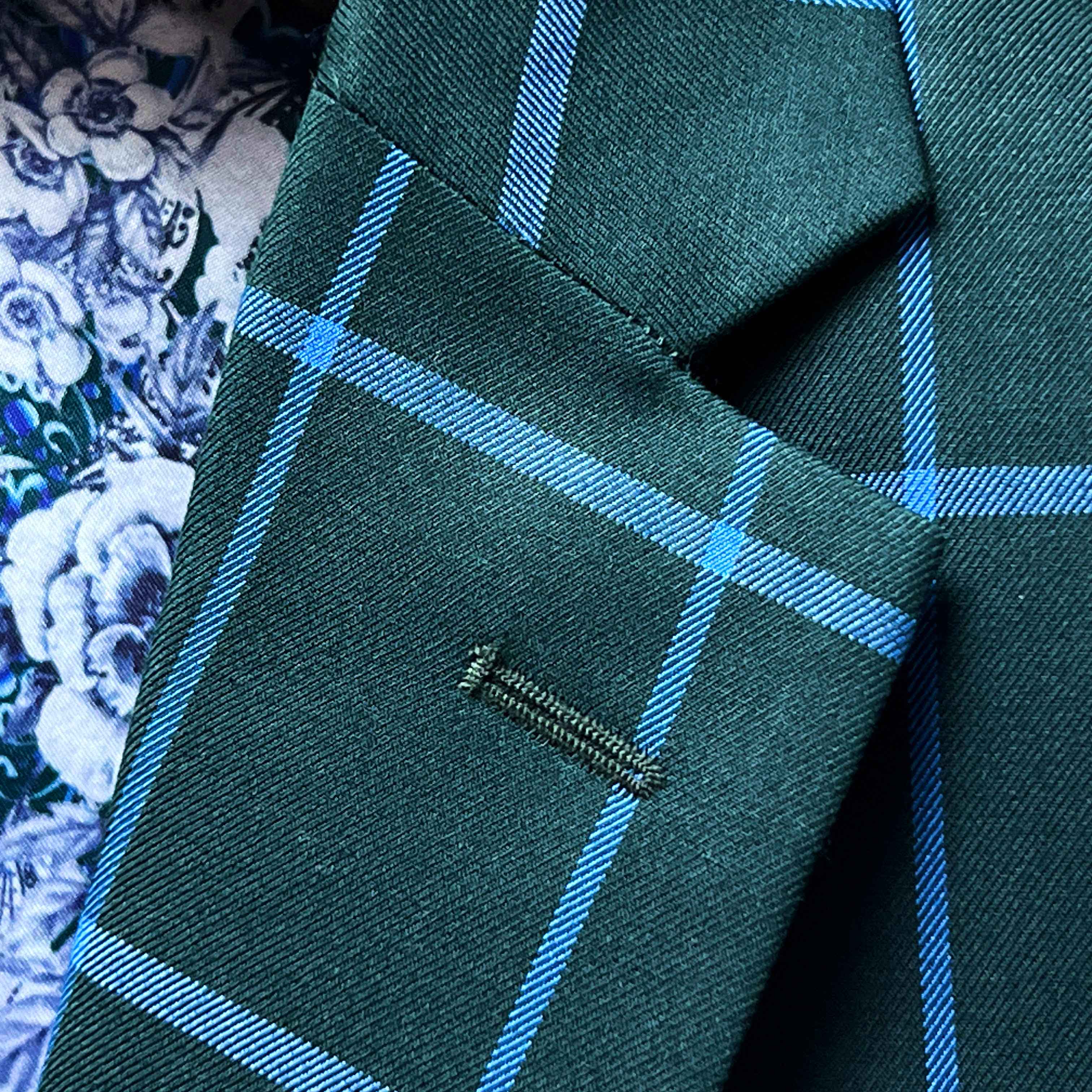 Classic notch lapel detail on forest green windowpane sport coat showing hand pick stitching and bright blue check pattern