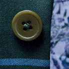 Close-up of green tortoise shell buttons on forest green windowpane sport coat showing natural patterns