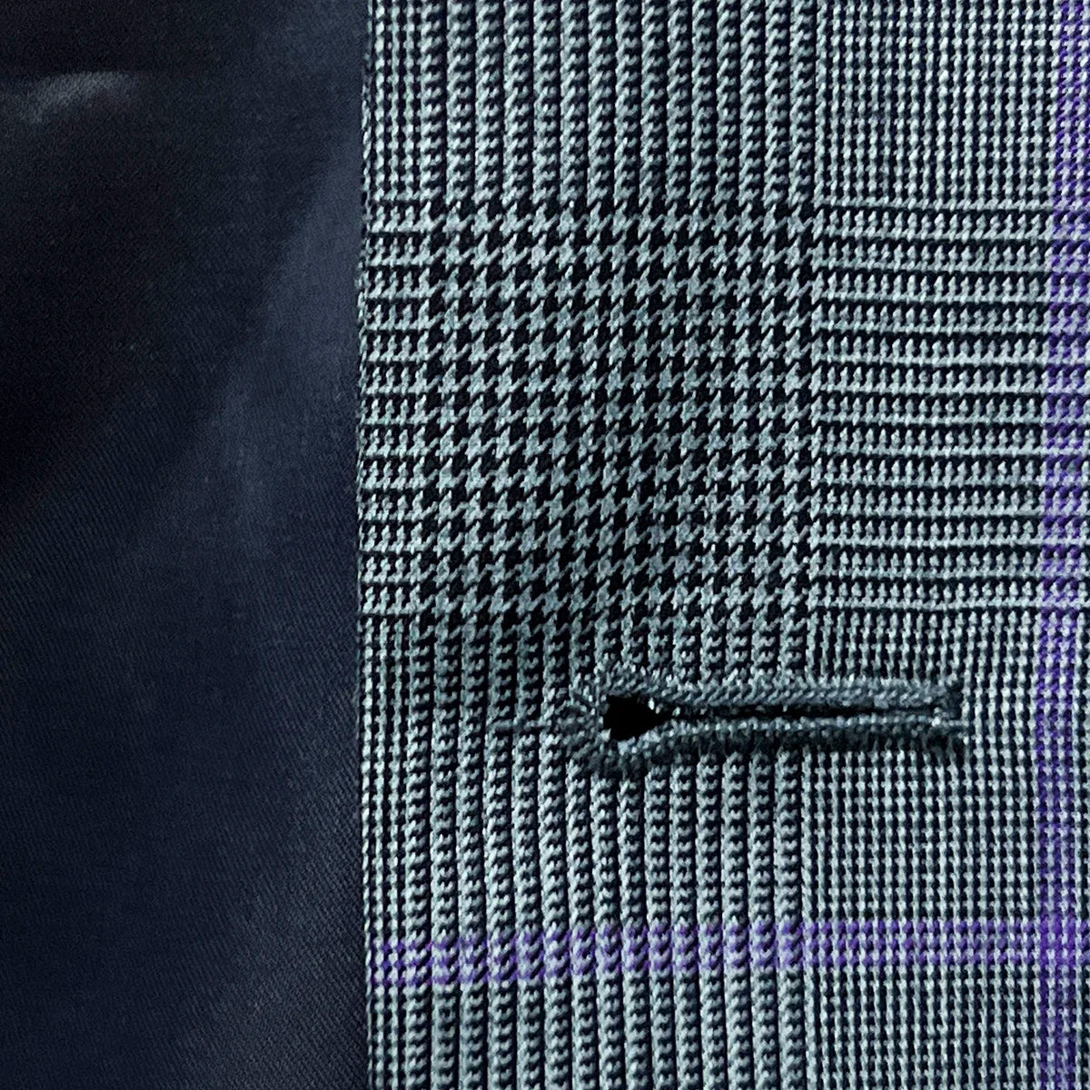 Macro view of precisely stitched buttonhole on grey suit fabric