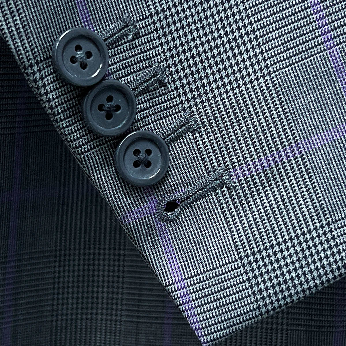 Detailed shot of suit jacket sleeve, showcasing working buttonholes and horn buttons