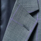 Detailed view of suit jacket's notch lapel, highlighting the Prince of Wales plaid pattern