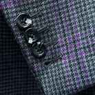 Detail shot of functional buttonholes on sleeve cuff of grey and purple plaid sport coat