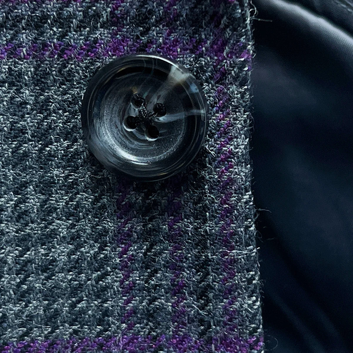 Detailed view of grey marble horn buttons used on custom plaid sport coat