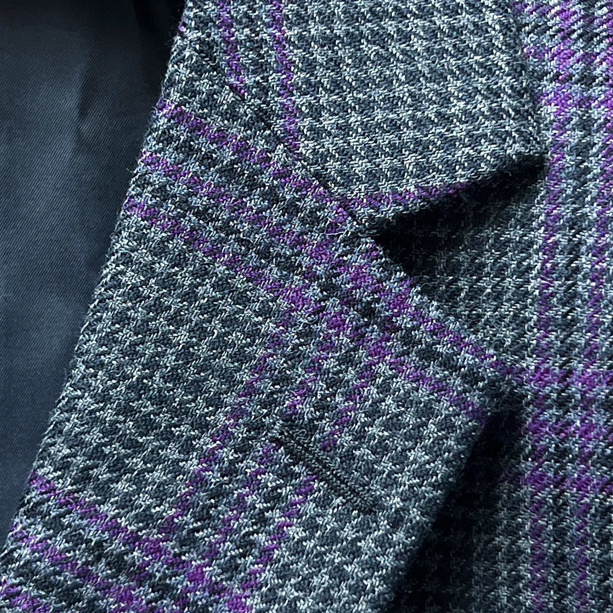 Detail of classic notch lapel on custom grey houndstooth sport coat with purple plaid accents