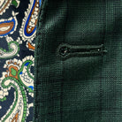 Detailed macro shot of hand-finished buttonhole stitching on hunter green checkered sport coat with black contrast thread