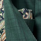 Detailed close-up of Super 120's wool fabric texture showing hunter green base with sophisticated black checkered pattern
