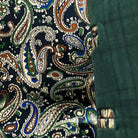 Colorful flash lining detail visible at jacket cuffs and vents in paisley pattern with navy, rust, green and light blue