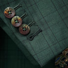 Sport coat jacket sleeve cuff showing functional buttonholes with contrast black accent stitching on hunter green checkered fabric
