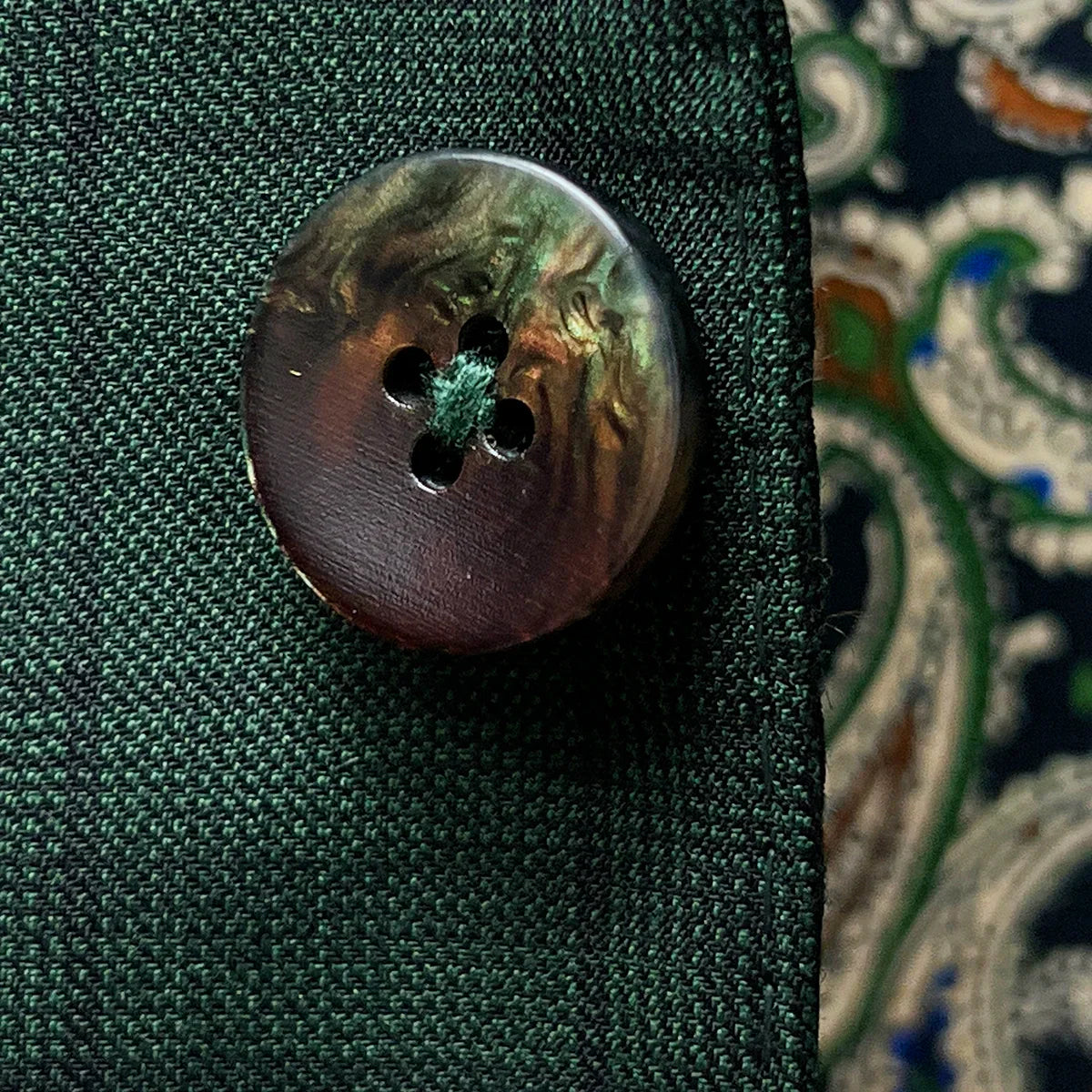 Close-up of walnut brown with green horn buttons showing natural marble-like patterns and rich coloring