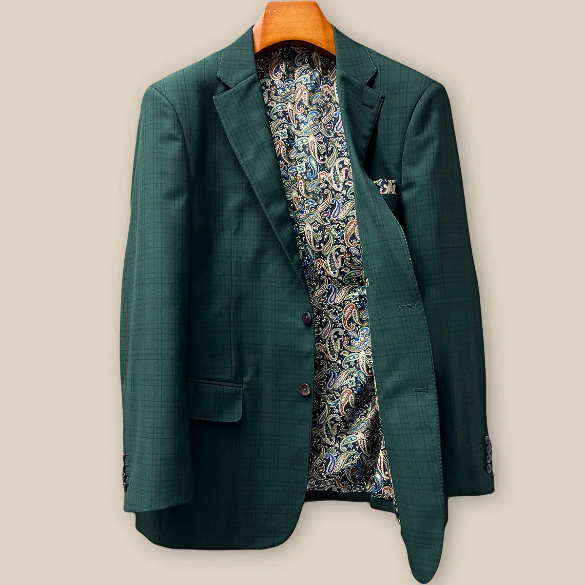 Interior left side of hunter green checkered sport coat jacket displaying vibrant paisley lining with navy, rust, green and light blue with inner pocket