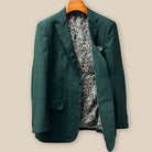 Interior left side of hunter green checkered sport coat jacket displaying vibrant paisley lining with navy, rust, green and light blue with inner pocket