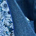 Detailed view of indigo blue herringbone tweed fabric texture showing distinctive diagonal pattern and soft lambswool finish