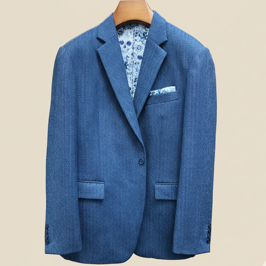 Front button panel of indigo blue herringbone tweed sport coat featuring deep navy blue button and hand pick stitching