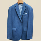 Front button panel of indigo blue herringbone tweed sport coat featuring deep navy blue button and hand pick stitching