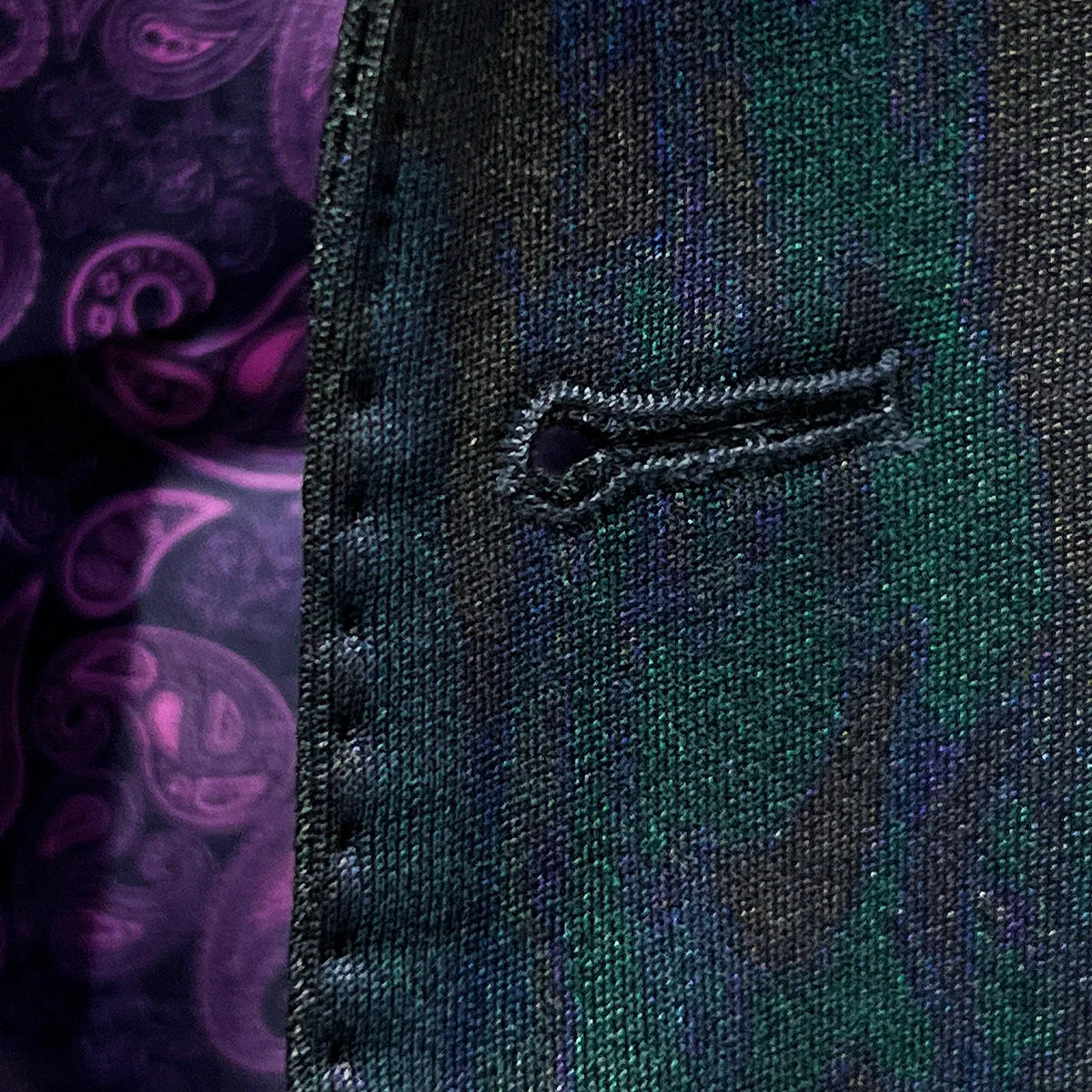 Detailed macro shot of hand-finished buttonhole stitching on iridescent teal green purple black tuxedo fabric