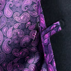 Colorful flash lining detail visible at jacket cuffs and vents in vibrant purple paisley pattern complementing the exterior