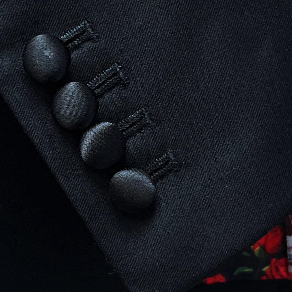 Close-up of working buttonholes on jacket sleeve with silk satin-faced buttons