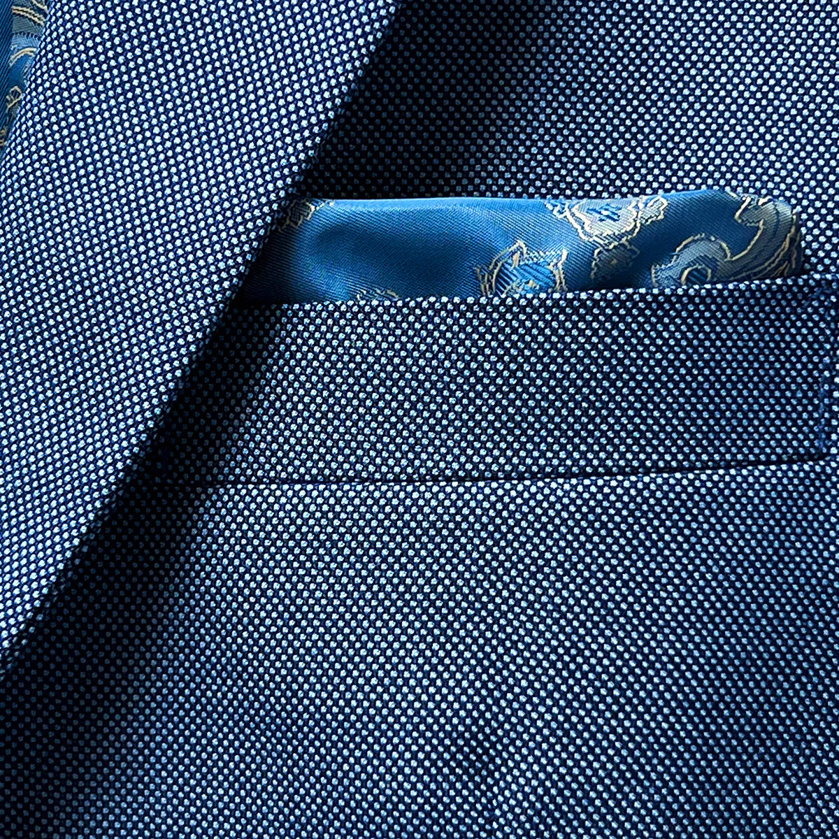 Close-up of suit jacket breast pocket with built-in pocket square in complementary color