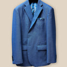 Close-up of light blue birdseye suit jacket sleeve with royal blue accent buttonhole