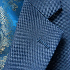 Detail of light blue birdseye suit jacket focusing on the classic notch lapel